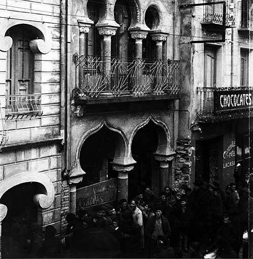 Cola para comprar el periódico en la imprenta Abad en los años treinta. La casa de aires granadinos es la del fotógrafo Lasheras, autor de la imagen. Más a la derecha, Chocolates Lacasa. Tres establecimientos históricos de la ciudad.